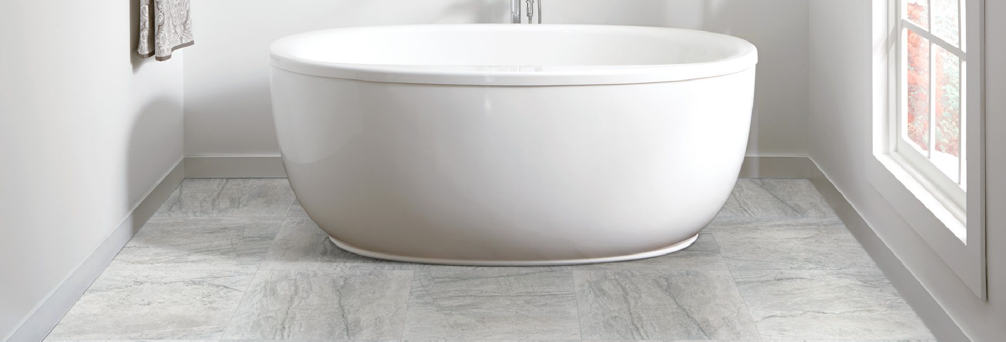 white bathtub on light grey tile floor